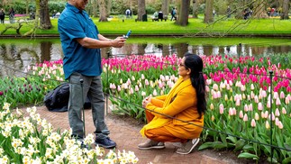 A couple poses for a photo in front of the tulip garden at Keukenhof Gardens in Lisse, near Amsterdam, Netherlands — Photo: Nick Gammon / AFP