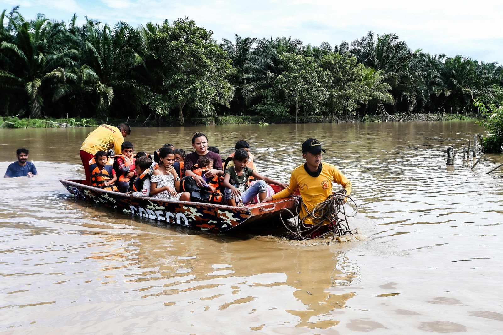 Pessoas afetadas por inundações causadas pela tempestade tropical Julia são evacuadas de barco, no município de Choloma, departamento de Cortes, Honduras  — Foto: WENDELL ESCOTO/AFP