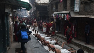 Hindus oferecem orações rolando no chão como parte de ritual do festival 'Madhav Narayan', nos arredores de Katmandu, Nepal — Foto: PRAKASH MATHEMA/AFP
