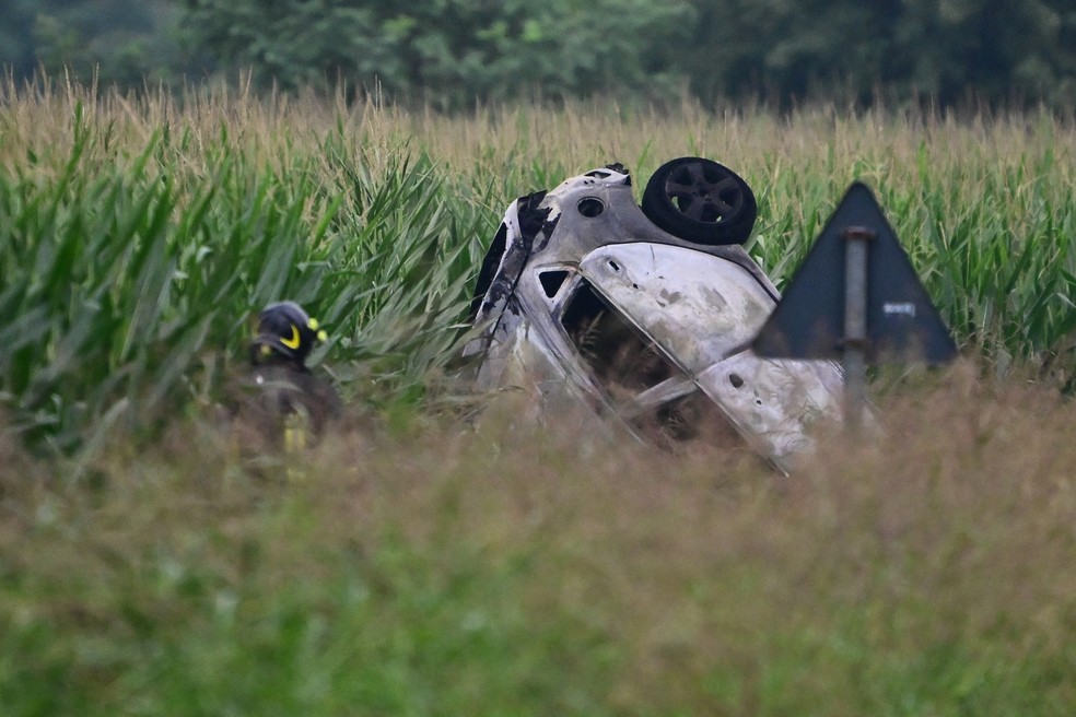 Restos de carro atingido por avião da equipe nacional de acrobacias que caiu após acidente durante a decolagem em Torino — Foto: Marco Bertorello/AFP