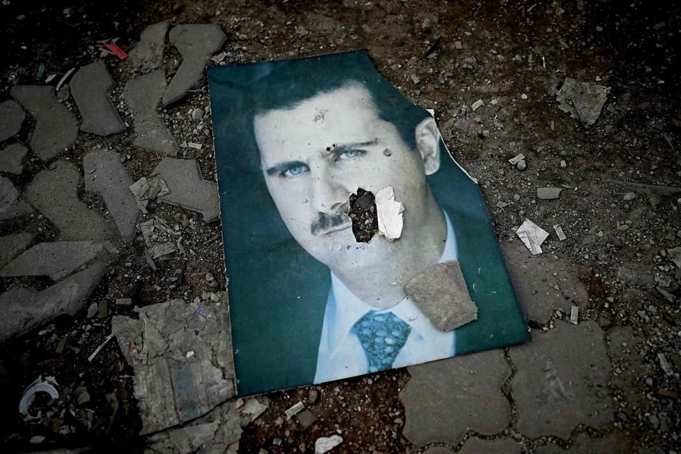 Portrait of deposed Syrian dictator Bashar al-Assad thrown on a street in Latakia — Photo: Ozan KOSE / AFP