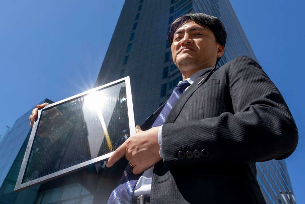 Yukihiro Kaneko, pesquisador da Panasonic, segurando um painel de perovskita durante uma entrevista à AFP em um laboratório da Universidade de Tóquio — Foto: KAZUHIRO NOGI / AFP