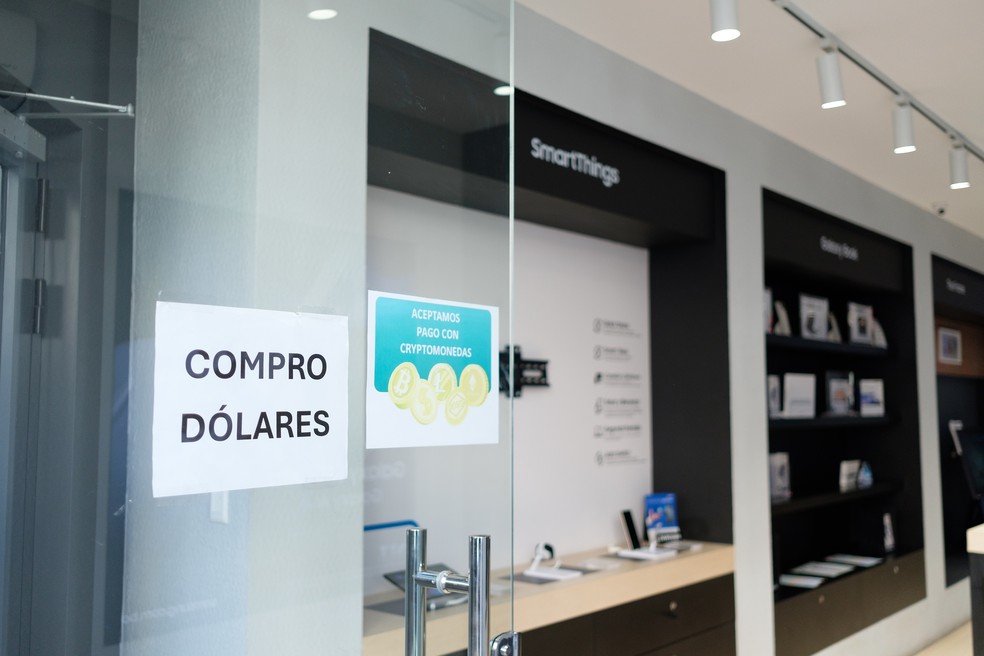 placas afixadas do do do de fora de uma loja deletretônicosem la paz informam os os os que eles eles compramdólarese aceitam criptomoedas -foto: manuel seoane/bloomberg