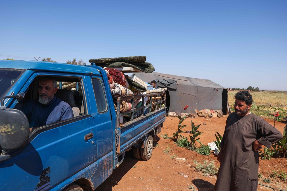Moradores beduínos desmontam seu acampamento nas proximidades da vila drusa de al-Mazraa, na província de Sweida, fugindo dos combates — Foto: Bakr ALKASEM / AFP
