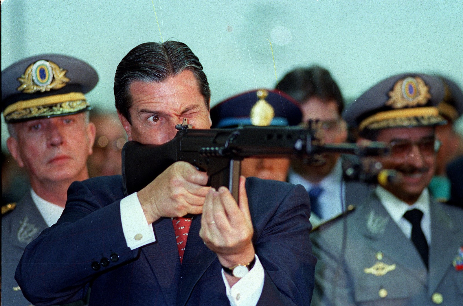 O presidente Fernando Collor durante cerimônia militar aponta um fuzil do Exército, em 1990 — Foto: Marcelo Carnaval / Agência O Globo