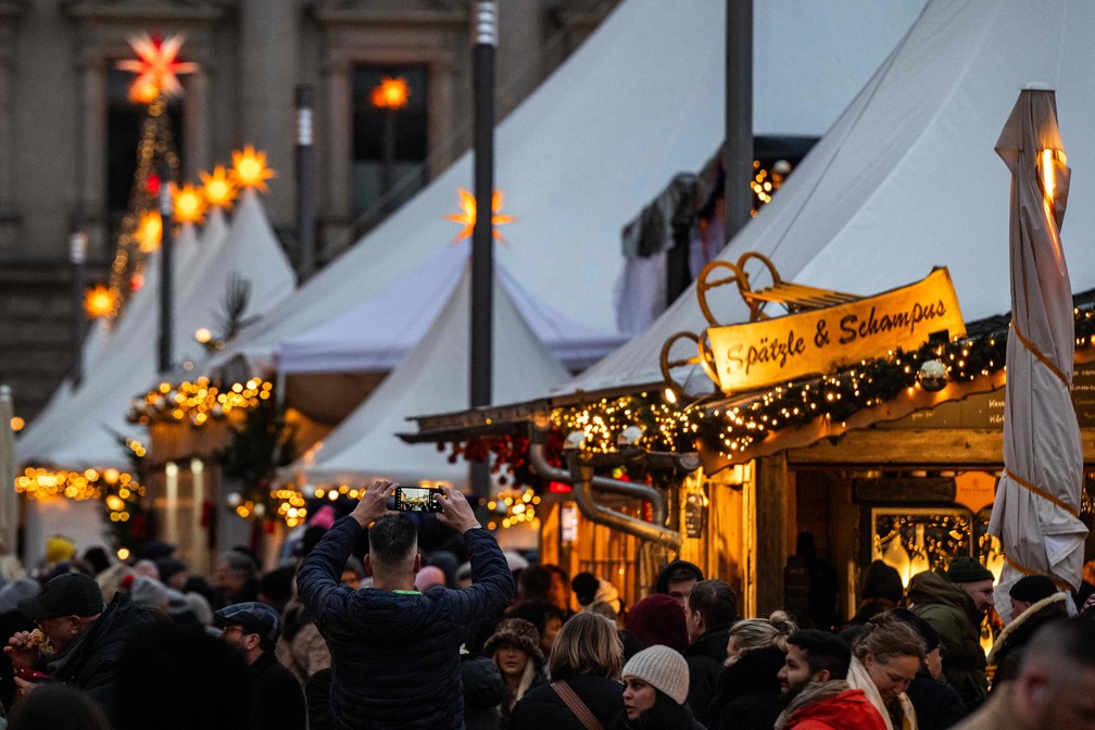Um visitante tira uma fotografia com seu celular no tradicional mercado de Natal em Berlim, na Alemanha — Foto: AFP/John Macdougall