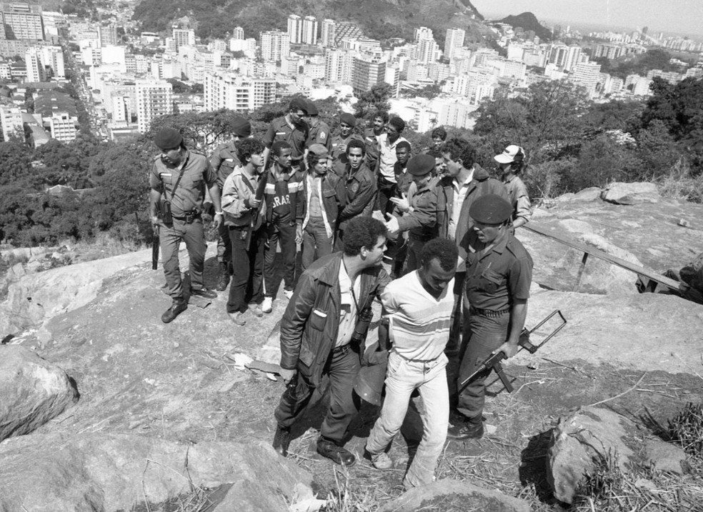 PMs com suspeitos presos no alto do Morro Dona Marta — Foto: Marcelo Régua/Agência O GLOBO