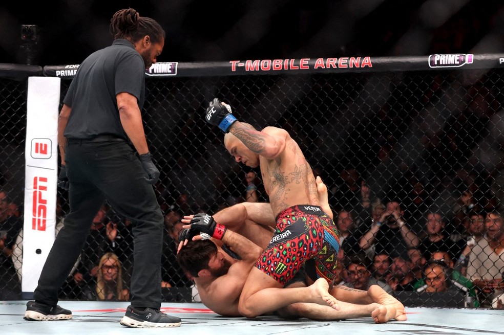 Alex Pereira do Brasil (R) dá um soco em Magomed Ankalaev durante uma luta pelo título dos meio-pesados ​​​​no UFC 32