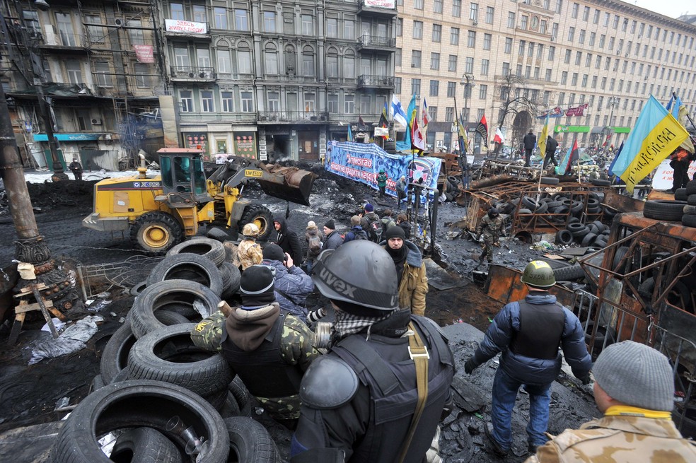 Ativistas ucranianos formam barricada na Praça da Independência, em Kiev, durante protesto em fevereiro de 2014 — Foto: GENYA SAVILOV / AFP