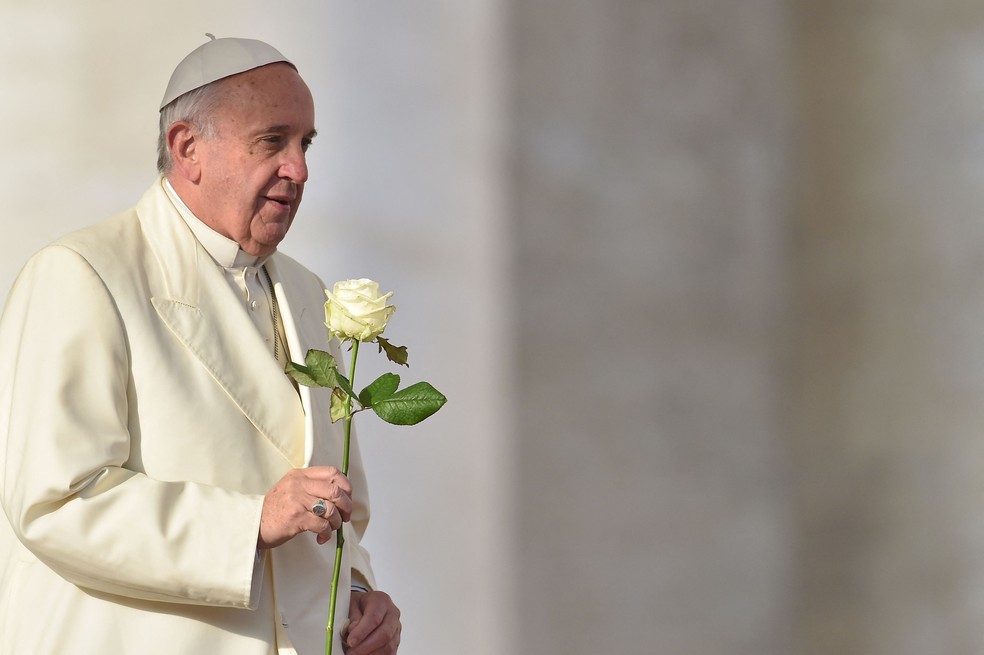 Papa Francisco oferece uma rosa branca à Virgem Maria durante sua audiência geral semanal na Praça de São Pedro, no Vaticano, em dezembro de 2015 — Foto: Vincenzo Pinto/ AFP