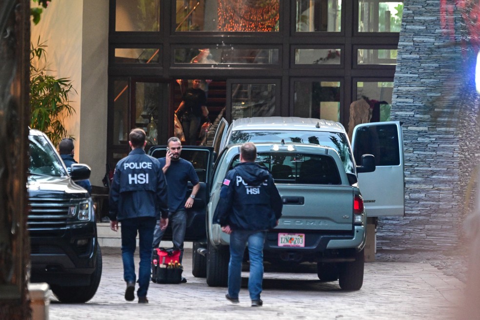 Agentes são vistos na entrada da casa do produtor e músico norte-americano Sean "Diddy" Combs em Star Island em Miami Beach — Foto: AFP