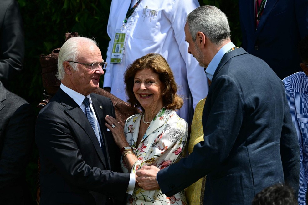 O rei Carl XVI Gustaf e a rainha Silvia, da Suécia, conversam com o presidente da COP30, embaixador Andre Corrêa do Lago durante foto de família da Cúpula do Clima — Foto: Pablo PORCIUNCULA / AFP