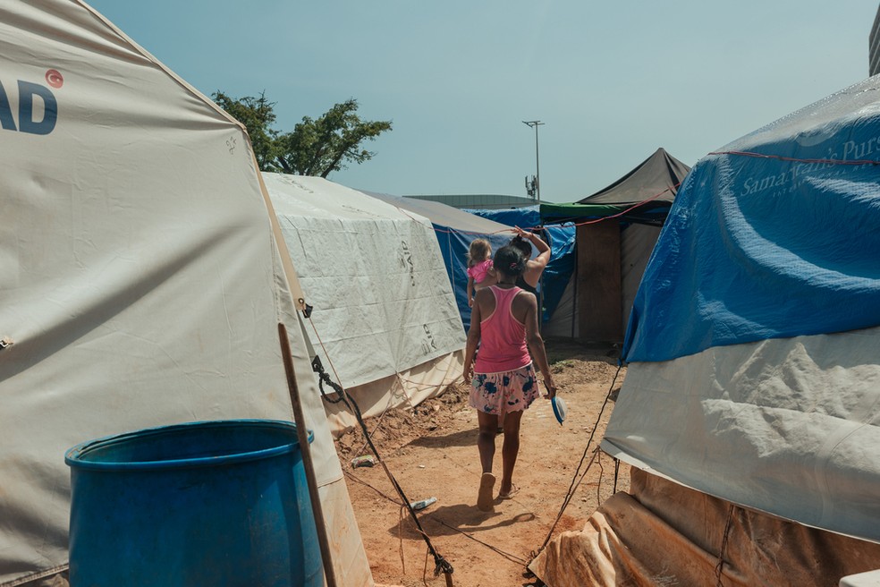 Milaidy Mateus, de 59 anos, caminha com sua vizinha Faurianis Ochoa, de 19 anos, e Ashley Colmenares, de 3 anos, em um acampamento montado do lado de fora de um conjunto habitacional que desabou parcialmente durante os dois terremotos — Foto: Adriana Loureiro Fernandez/MSF