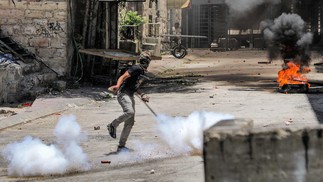 Manifestante palestino atira pedras durante confrontos com forças israelenses no centro de Hebron, em 4 de julho de 2023 — Foto: MOSAB SHAWER / AFP