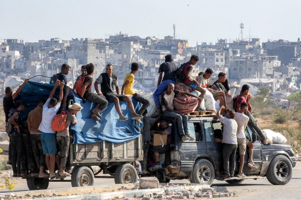Civis a bordo de veículo carregado com ajuda humanitária em Gaza — Foto: Eyad BABA / AFP