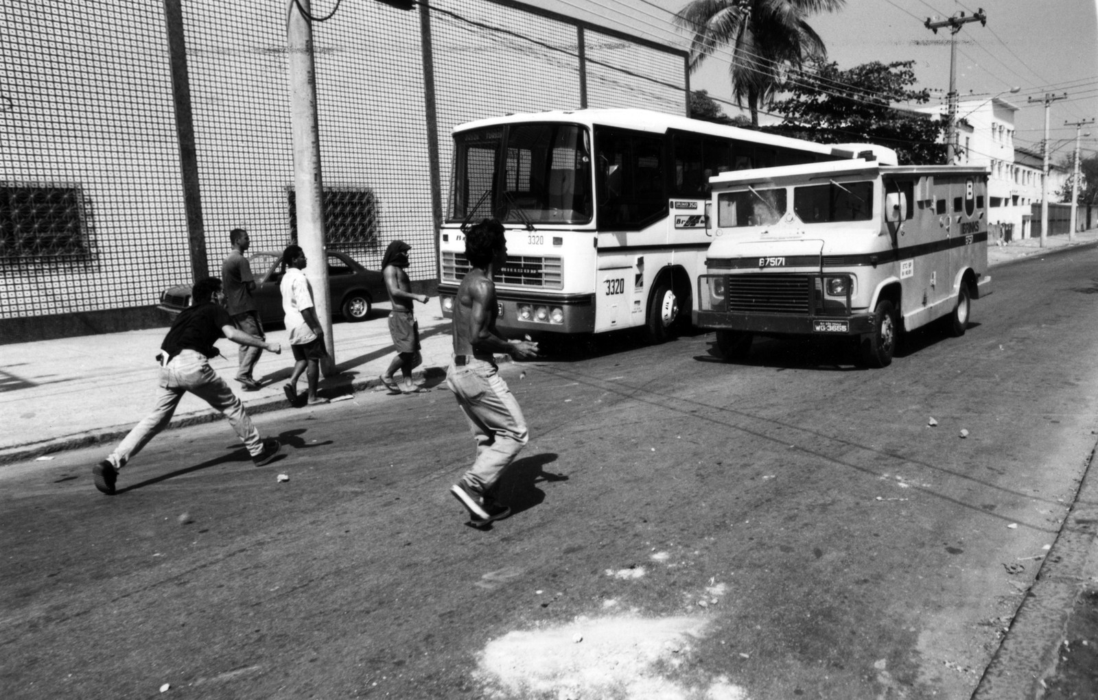 Moradores atiram pedras em PMs, veículos e um carro-forte que tenta furar o bloqueio  — Foto: Ivo Gonzalez / Agência O Globo