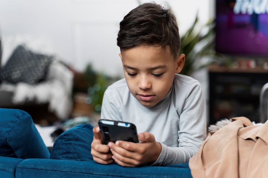 Menino no celular: uso de apetrecho requer cautela dos pais