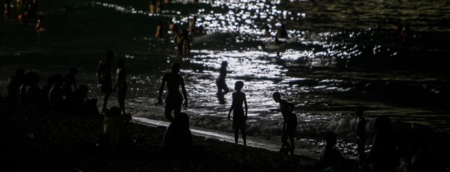 Cariocas e turistas aproveitam mar do Arpoador em noite quente do verão.   — Foto: Brenno Carvalho