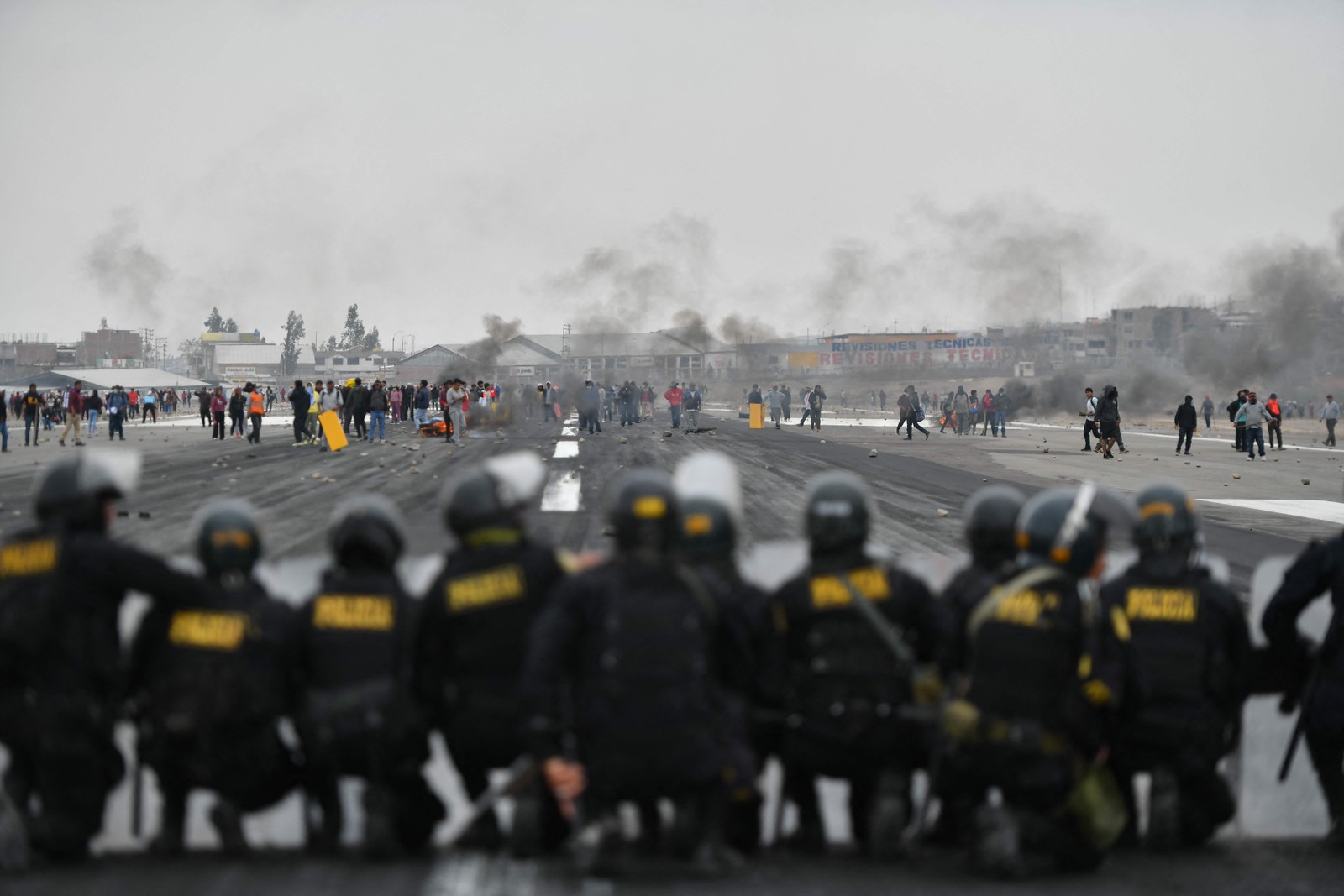 Com pedras, pedaços de pau e pneus em chamas, centenas de manifestantes bloqueiam a pista do aeroporto de Arequipa — Foto: Diego Ramos / AFP