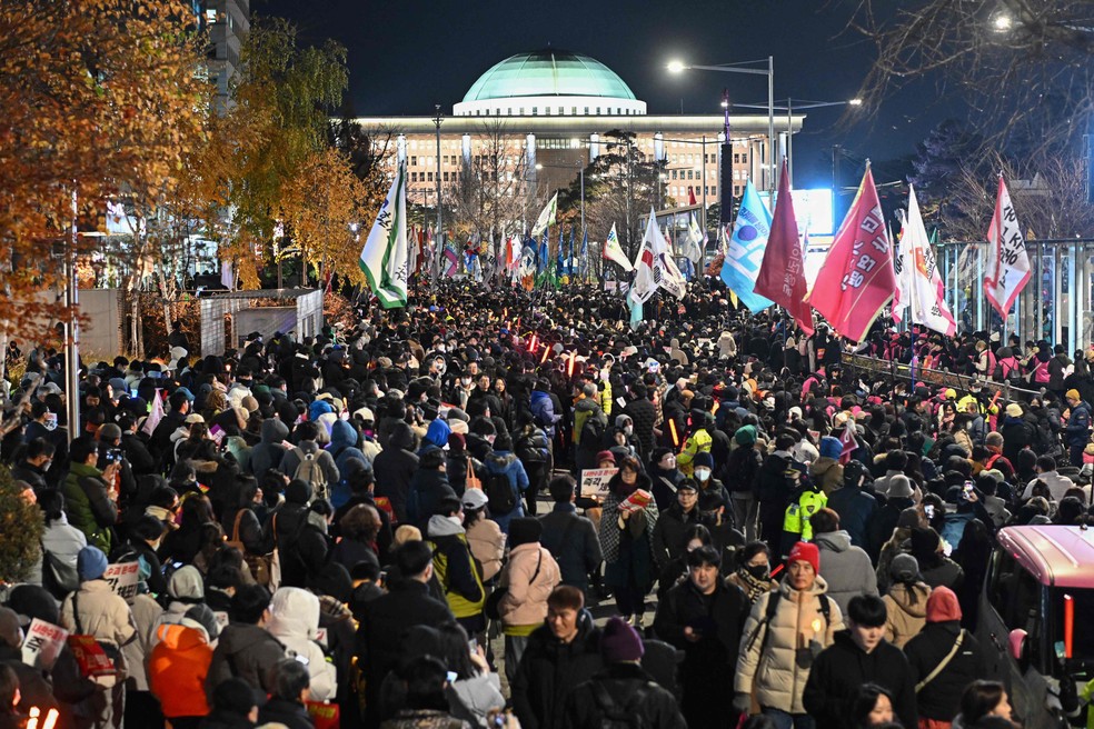 Multidão realiza protesto diante da Assembleia Nacional da Coreia do Sul, em Seul — Foto: Philip FONG / AFP