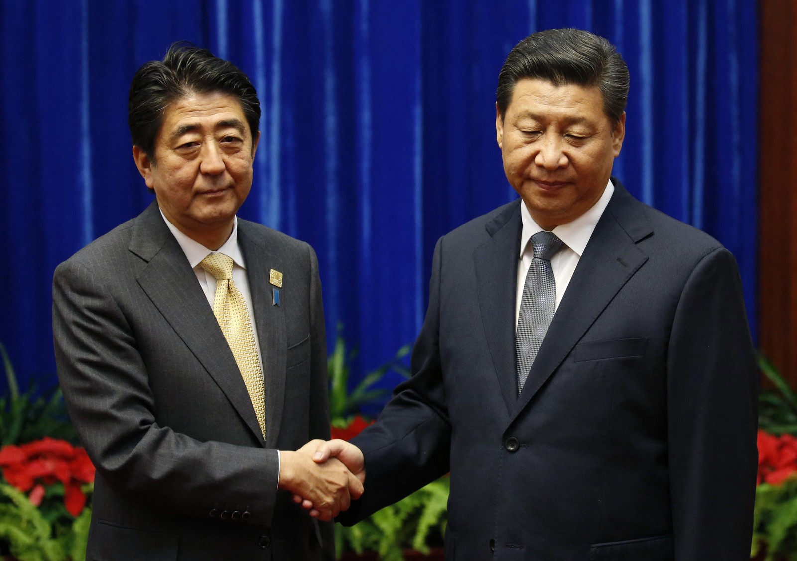 Presidente da China Xi Jinping cumprimenta o primeiro-ministro do Japão Shinzo Abe, no Grande Salão do Povo, à margem da Cúpula de Cooperação Econômica Ásia-Pacífico (APEC), em Pequim  — Foto: KIM KYUNG-HOON / AFP 