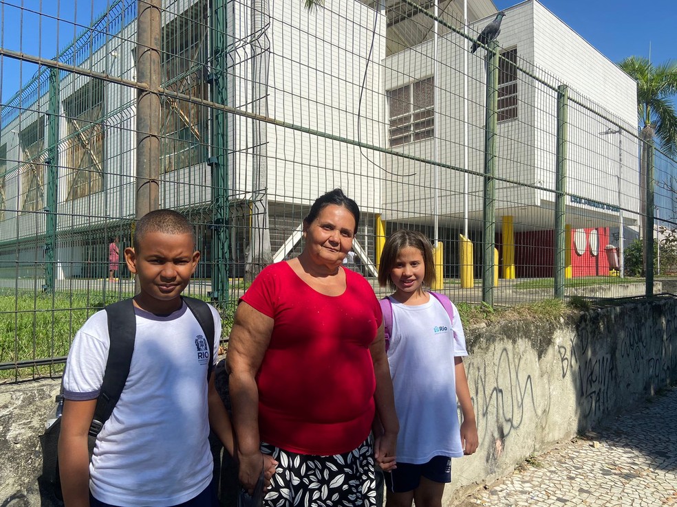 Elena Cristina, de 56 anos, com seus netos Ana Vitória, 9 anos e Samuel Henrique, 11 anos, em frente à Escola Municipal Tia Ciata — Foto: O Globo