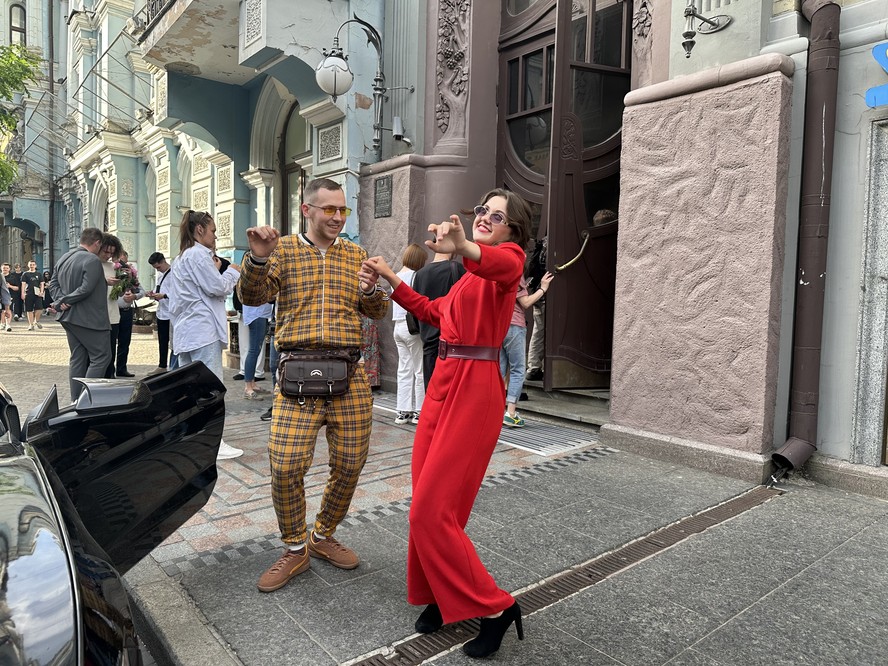 Casal de atores de teatro chamam o público para ver peça em rua de Kiev