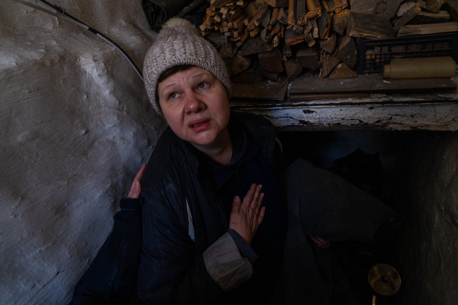Maryna reza enquanto bombas guiadas disparadas pela força aérea russa sobrevoam o povoado de Netailove, a poucos quilômetros das linhas de frente. Neste dia, a senhora de 52 anos decidiu abandonar sua casa por temer que os combates logo chegariam a sua vila. Foto tirada em Netailove, Oblast de Donetsk, Ucrânia, em março de 2024 — Foto: Yan Boechat