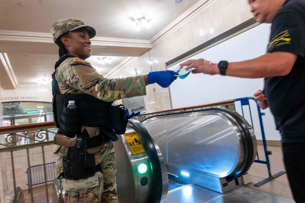 NOVA YORK, NOVA YORK – 16 de julho: Um soldado da Guarda Nacional entrega uma máscara facial a um passageiro no Grand Central Terminal enquanto a fumaça dos incêndios florestais no Canadá encobre Manhattan, em 16 de julho de 2026, na cidade de Nova York. A cidade de Nova York está sob alerta de saúde devido à qualidade do ar, enquanto a fumaça dos incêndios no Canadá e na região dos Grandes Lagos avança lentamente pela área, formando uma densa névoa em meio ao calor. Nova York e grande parte da Costa Leste enfrentam temperaturas com sensação térmica superior a 38°C, enquanto a região passa por mais uma onda de calor — Foto: SPENCER PLATT / GETTY IMAGES NORTH AMERICA / Getty Images via AFP