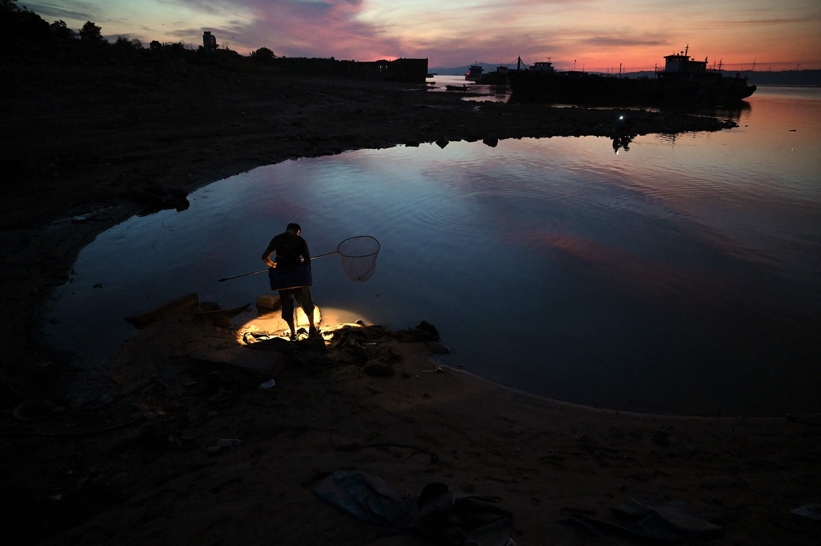 Pescador fica às margens do maior lago Poyang de água doce da China em Juijiang — Foto: NOEL CELIS / AFP