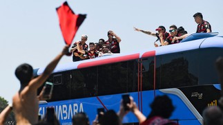 Brazil's Flamengo players celebrate as they leave on a bus the Galeao airport in Rio de Janeiro, Brazil, on November 30, 2025, a day after clinching the 2025 Copa Libertadores title — Foto: (Photo by Daniel RAMALHO / AFP)