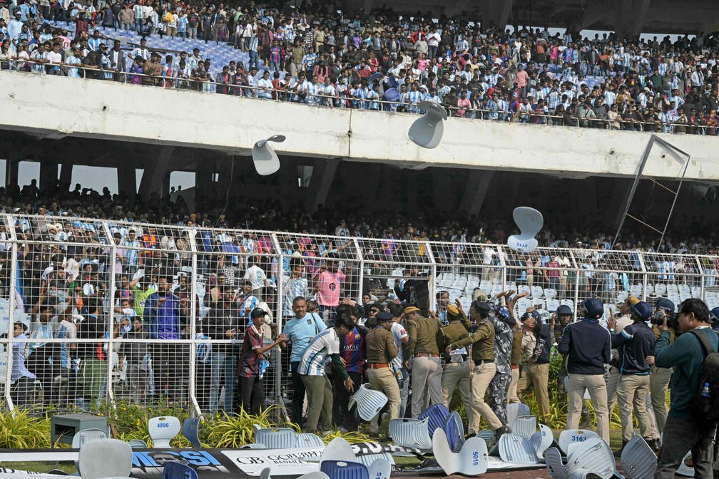 Supporters throw chairs onto the pitch after Messi's quick appearance on tour of India — Photo: Dibyangshu SARKAR / AFP