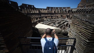 Turista fotografa o Coliseu de Roma, reaberto em 1 de junhoAFP
