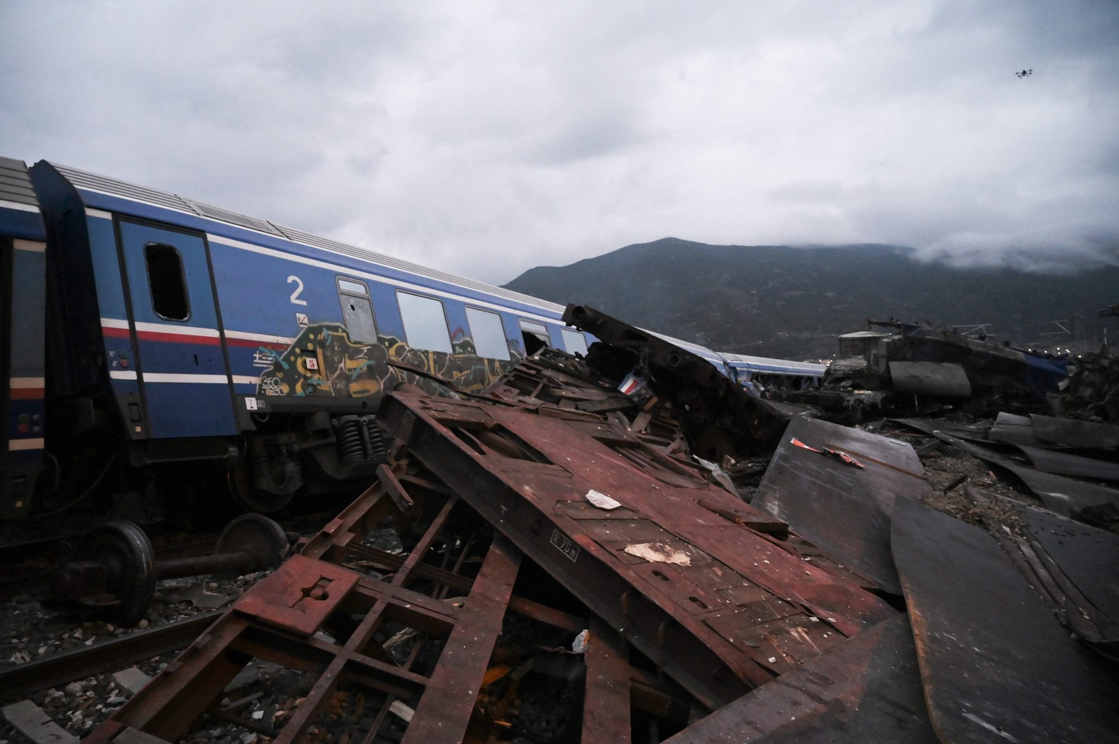 Vagões destruídos são vistos perto dos trilhos após um acidente de trem no vale Tempi, perto de Lárissa, Grécia, em 1º de março de 2023 — Foto: Sakis Mitrolidis / AFP