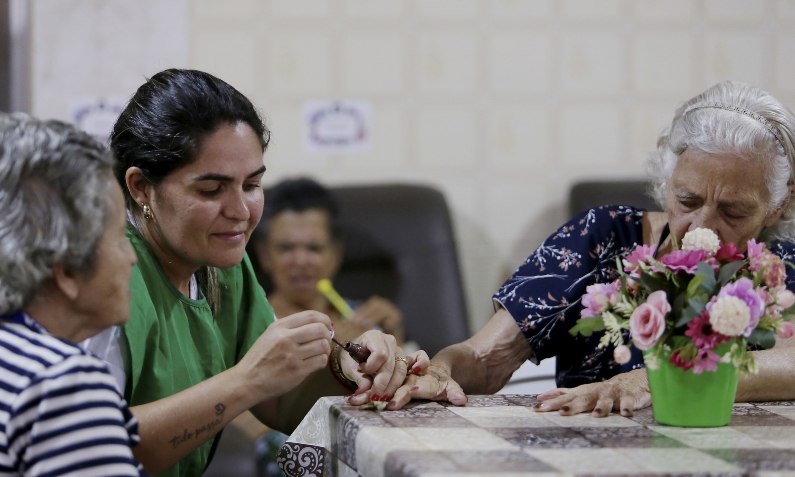 An elderly woman is painting her nails — Photo: Marcelo Thebald / Agência O Globo