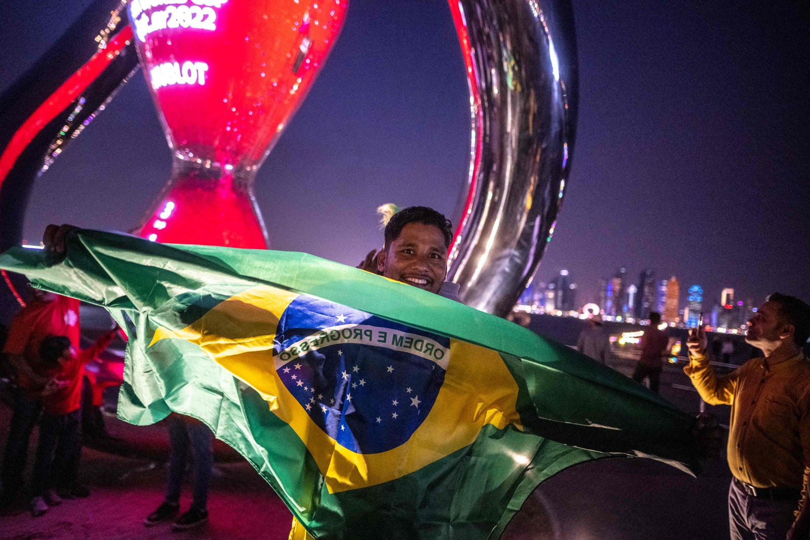 Torcedor do Brasil se em frente ao relógio de contagem regressiva da Copa do Mundo em Doha, em 17 de novembro — Foto: Philip FONG / AFP
