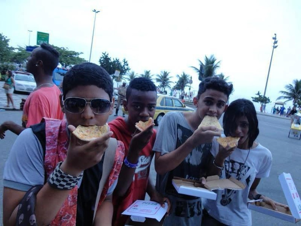 Leonardo dos Santos e amigos com as pizzas distribuídas para os fãs por Lady Gaga, em 2012, em Ipanema — Foto: Arquivo pessoal/ Leonardo dos Santos