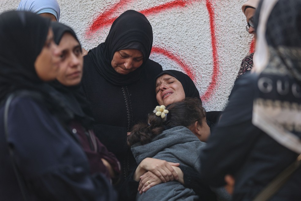 Mulheres palestinas choram no Hospital al-Shifa, em Gaza, que recebeu parte das vítimas dos bombardeios israelenses — Foto: Omar al-Qattaa/AFP