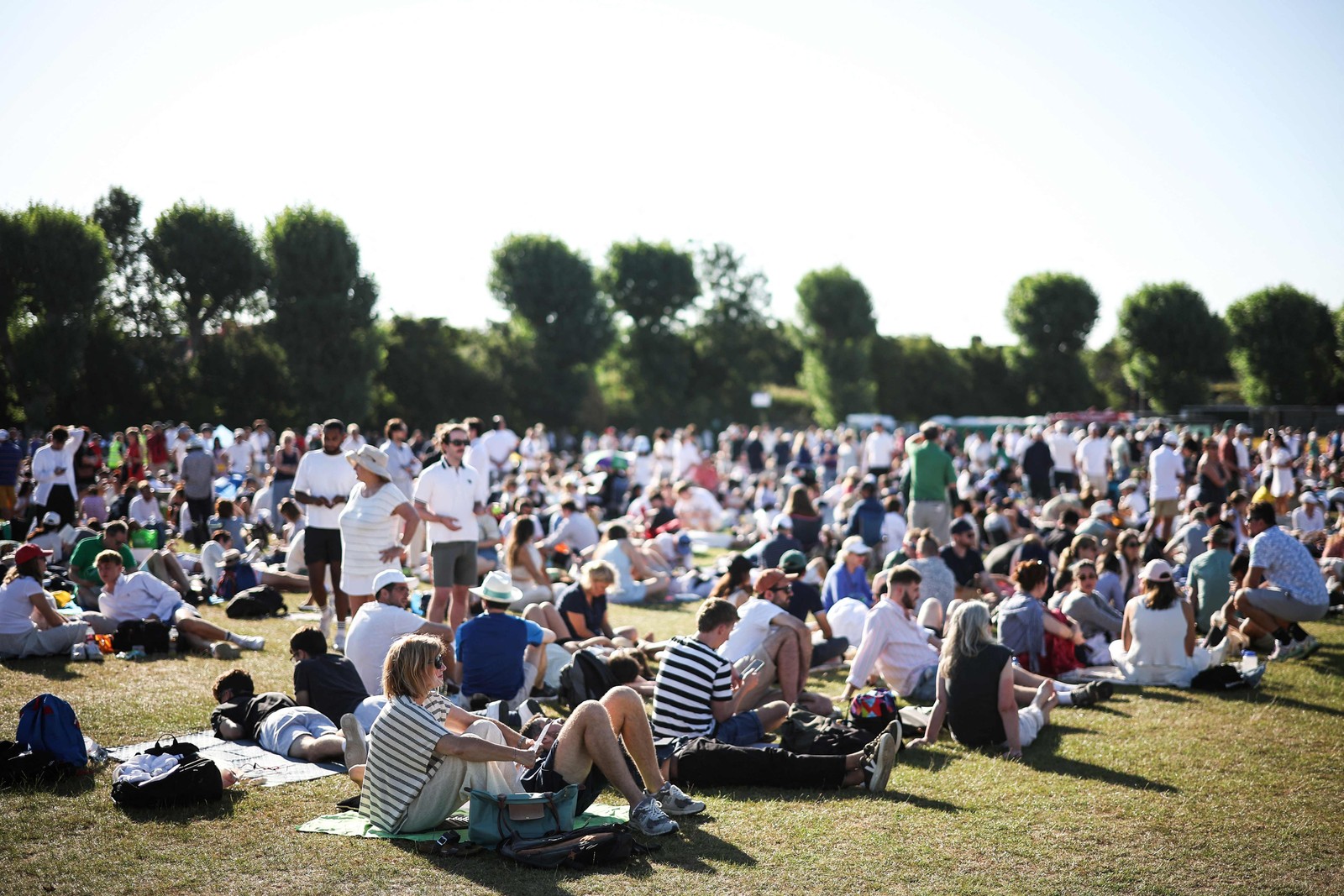 torcida sereúnesob forte calor para acompanhar torneio de wimbledon -foto: Henry Nichols/AFP