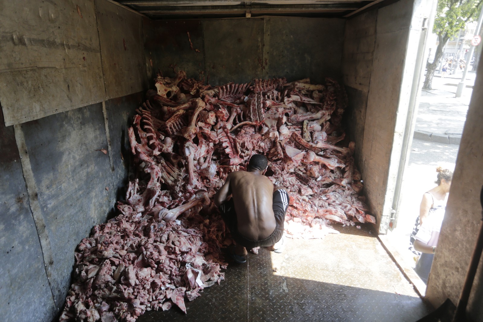 Em setembro do ano passado, imagem que já traduzia a luta para tentar driblar a fome: em busca de algum alimento, pessoas recolhiam ossos e pelancas descartadas de supermercados na Glória, Zona Sul do Rio — Foto: Domingos Peixoto / Agência O Globo