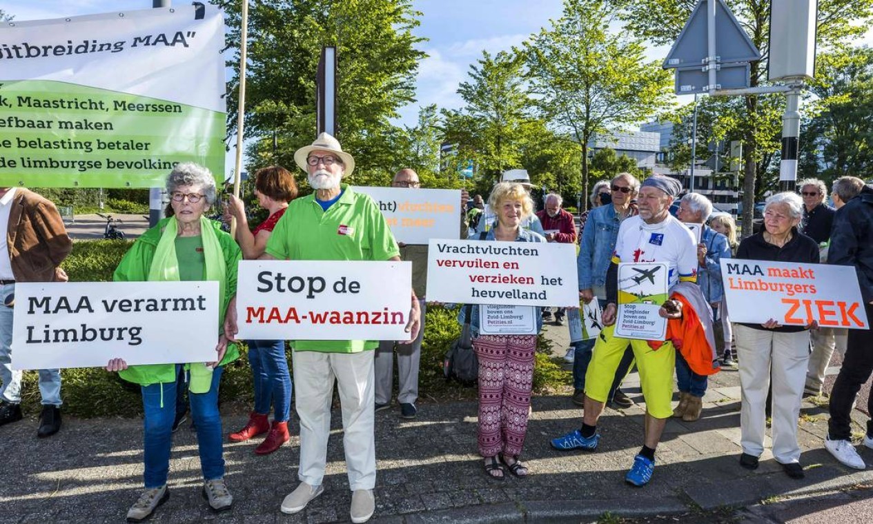 Funcionários do aeroporto seguram protestam pela manutenção de seus empregos no aeroporto de Maastricht Aachen, em Maastricht, Holanda, que está na iminência de ser fechado, pelo impacto ambiental na vizinhança  — Foto: MARCEL VAN HOORN / AFP