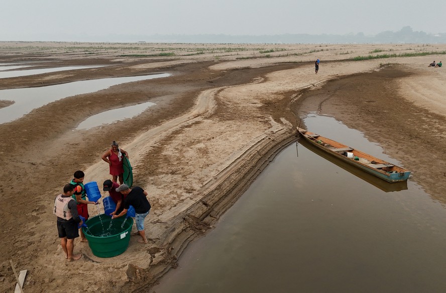Moradores coletam água em banco de areia do Rio Madeira, na Amazônia, no último sábado