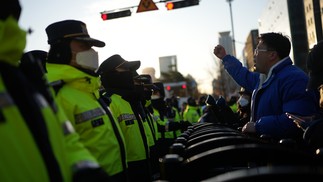 Policiais fazem guarda na Praça Gwanghwamun, em Seul, enquanto manifestantes pedem a destituição de Yoon Suk-yeol, após a breve imposição da lei marcial — Foto: Chang W. Lee/The New York Times
