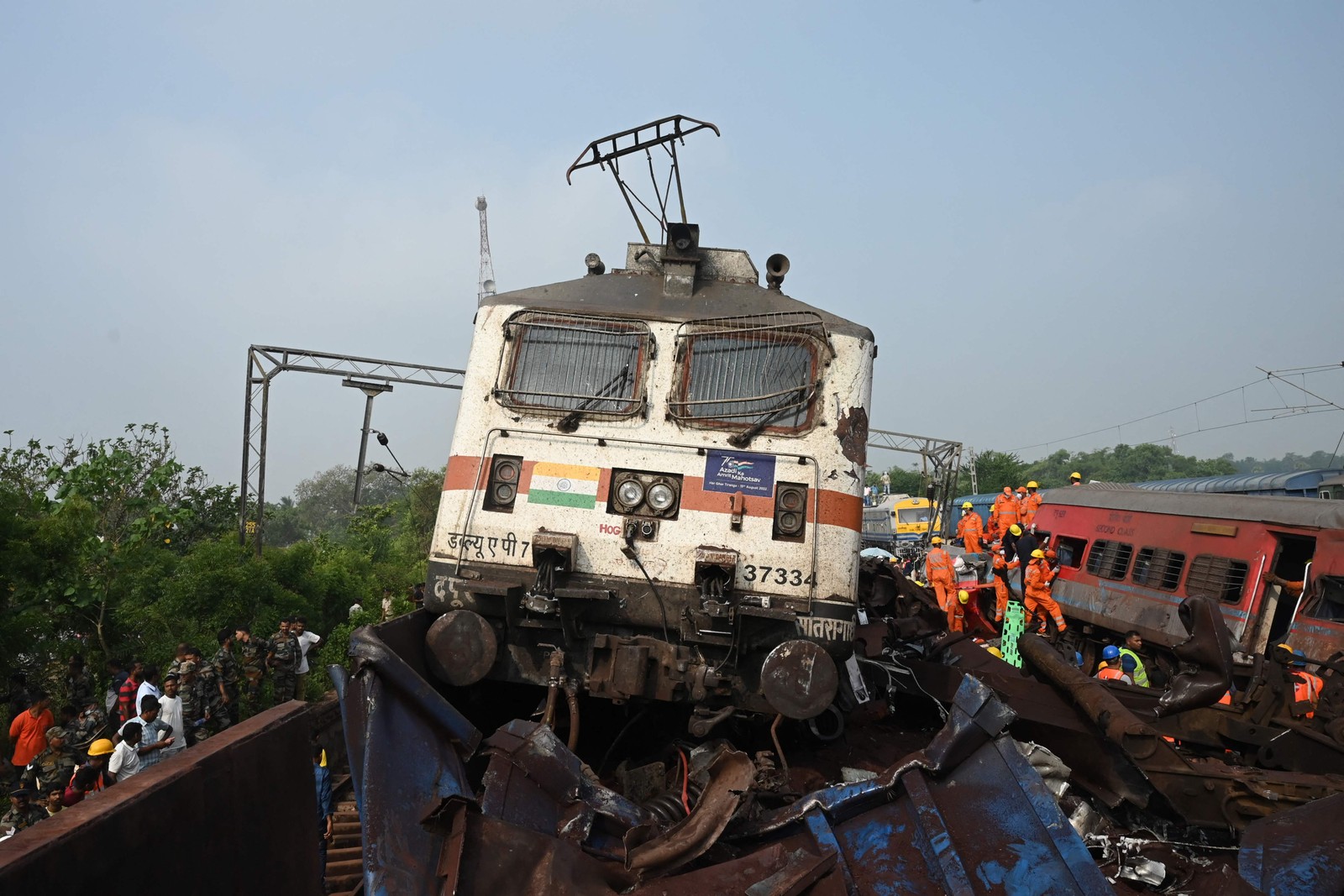 Equipes de resgate se reúnem em torno dos trens danificados no local da colisão perto de Balasore, a cerca de 200 km da capital do estado Bhubaneswar — Foto: DIBYANGSHU SARKAR / AFP)