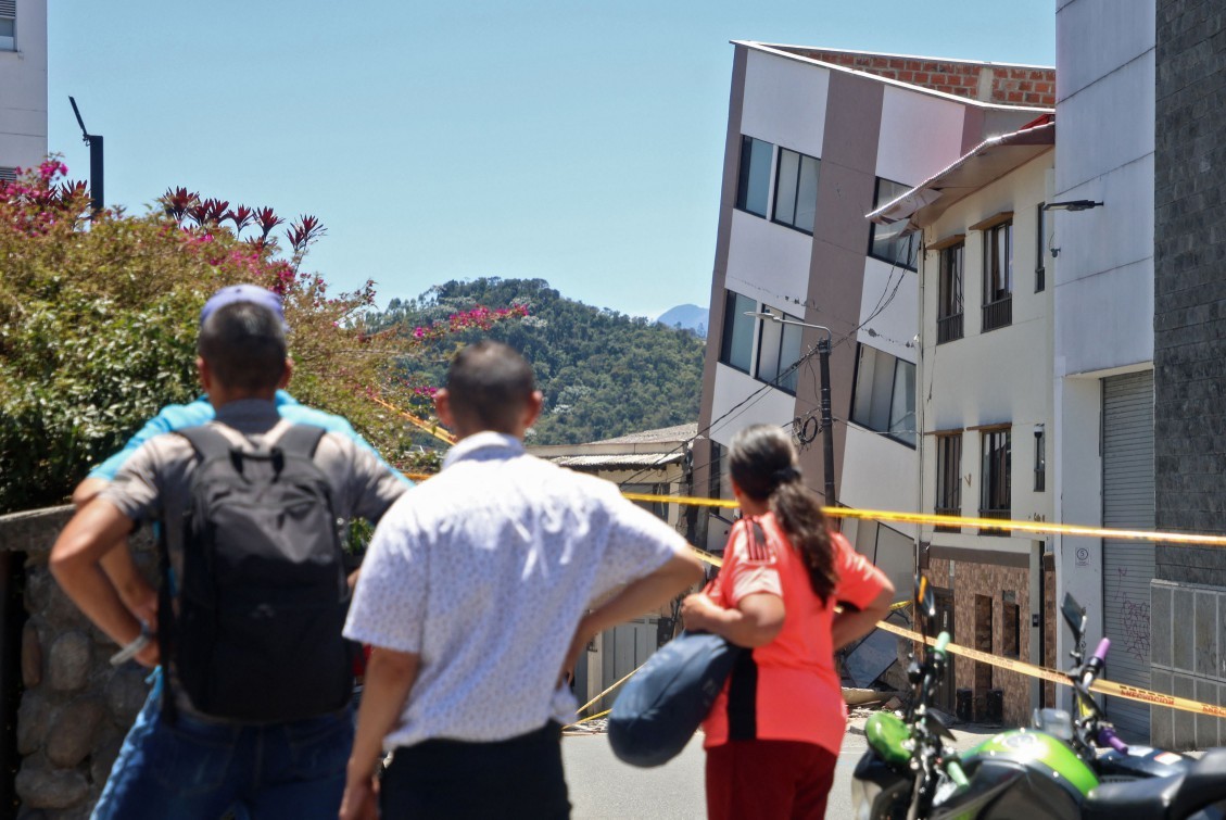 Pessoas observam um edifício danificado após um terremoto em Manizales, Colômbia. — Foto: Giovanny Galvez / AFP