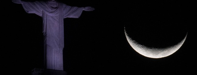 A lua crescente é vista ao lado da estátua do Cristo Redentor no Rio de Janeiro — Foto: MAURO PIMENTEL / AFP