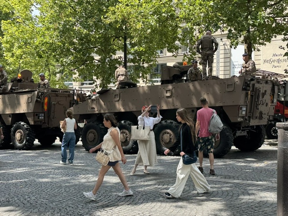 Veículos militares desfilam por Paris — Foto: Paola de Orte