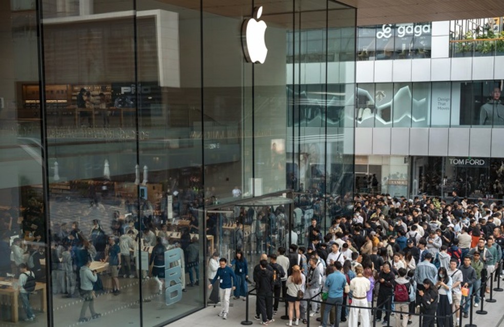 Clientes fazem fila para retirar suas compras pré-encomendadas na loja Apple Sanlitun, em Pequim — Foto: Bloomberg