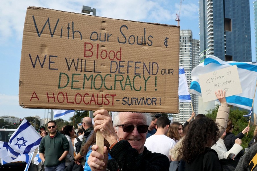 Manifestantes israelenses levantam bandeiras e cartazes em Tel Aviv, contra as controversas reformas legais promovidas pelo governo de extrema direita do país