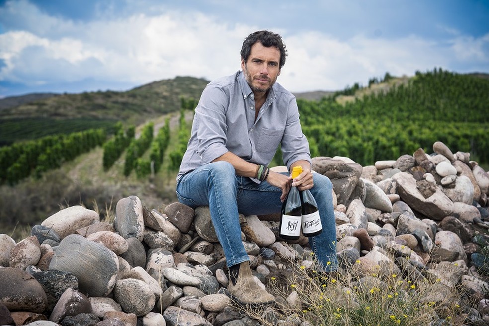 Sebastián Zuccardi com os vinhos Fósil e Botánico — Foto: Divulgação / Zuccardi